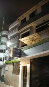um edifício com uma placa de pizza e um guarda-chuva em Park View Hostel & Suites em Manta