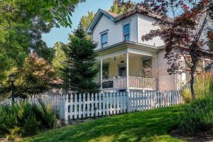 a white fence in front of a white house at Bluemoon Vacation Rentals - Anne Hathaway House in Ashland