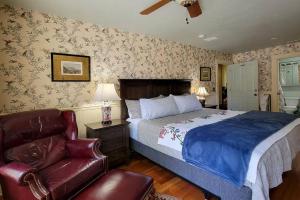a bedroom with a bed and a leather chair at Bluemoon Vacation Rentals - Anne Hathaway House in Ashland