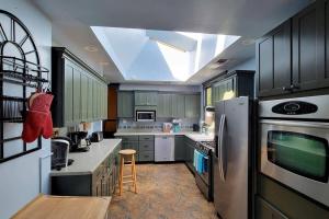 a kitchen with green cabinets and a skylight at Bluemoon Vacation Rentals - Anne Hathaway House in Ashland