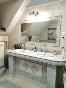 a bathroom with two sinks and a large mirror at Apartmaji ARKO in Ribnica