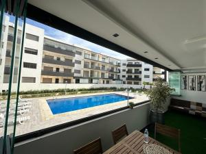 uitzicht op een zwembad vanaf het balkon van een appartement bij Appartement Bouznika Plage in Bouznika