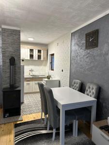 a kitchen and dining room with a white table and chairs at Kuća za odmor Pale - Jahorina in Pale