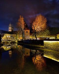 un puente sobre un río por la noche con una ciudad en Apartmaji ARKO en Ribnica