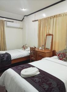 a hotel room with two beds and a mirror at Janh Ya phone Guesthouse in Pakbeng