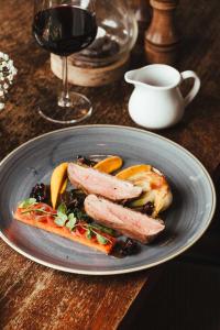 a plate of food with sausage and vegetables on a table at The Woolpack Inn in Wavehorne