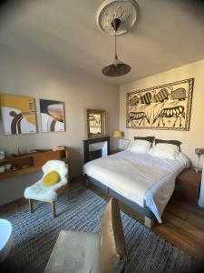 ein Schlafzimmer mit einem großen Bett und einem Stuhl in der Unterkunft Villa Tourelle in Dinan