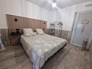 een slaapkamer met een bed met een houten hoofdeinde bij Super appartement les pieds dans l eau in Cap d'Agde