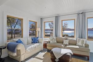 a living room with two couches and large windows at Villa Del Lago - Lakehouse in Pepin in Pepin