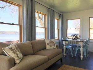 a living room with a couch and a table and windows at Villa Del Lago - Lakehouse in Pepin in Pepin