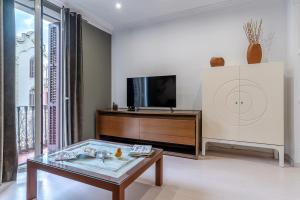 a living room with a tv and a coffee table at Enjoybcn Tapies Apartment in Barcelona