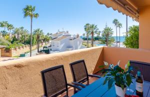 a balcony with a blue table and chairs and palm trees at Fantastic Apartment 80m from the Beach! in Marbella