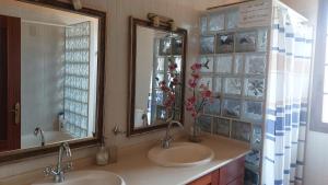 a bathroom with two sinks and a large mirror at Chalet Anagato in Tegueste