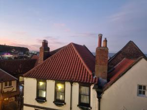 a house with a red roof with lights on it at Poppy Cottage in Whitby