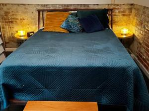 a bed with a blue comforter and two night stands at Knight Campbell Carriage House in Denver