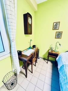 1 dormitorio con escritorio y reloj en la pared en Chambre privée à louer, en Seclin