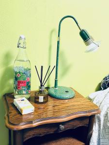 una mesa con una lámpara y una botella en ella en Chambre privée à louer, en Seclin