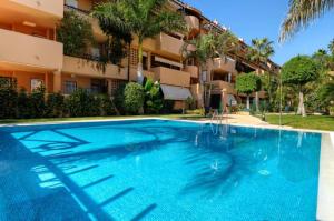 una gran piscina azul frente a un edificio en Fantastic Apartment 80m from the Beach!, en Marbella