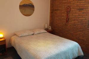 a bedroom with a bed and a brick wall at Casa de campo en El convento, Santo domingo in San Antonio