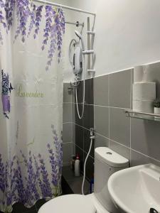 y baño con cortina de ducha y aseo. en Benoni 3 Bedroom - Farah Biz Empire Homestay, en Papar