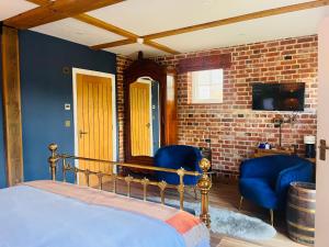a bedroom with a bed and two blue chairs at The Lion in East Bergholt