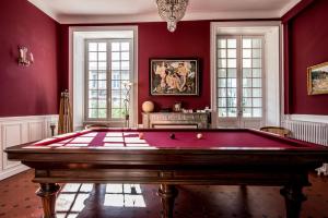 um quarto vermelho com uma mesa de bilhar em Gîte Château de Seguin em Lignan-de-Bordeaux