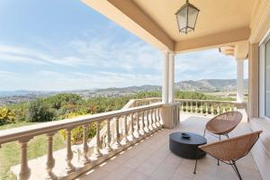 a balcony with chairs and a view of the mountains at Luxury Seaview Villa by Olala Homes in Teià