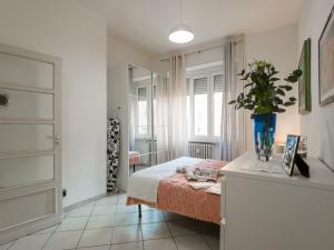 1 dormitorio con 1 cama y un jarrón de flores en MFS San Marino Host, en Turín