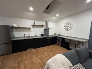 a living room with a couch and a kitchen at New Build Cosy Bungalow near Bath and Bristol in Wick