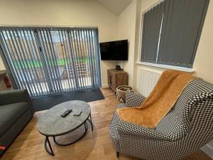 a living room with a couch and a table at New Build Cosy Bungalow near Bath and Bristol in Wick
