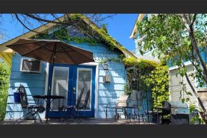 uma casa azul com uma mesa e cadeiras e um guarda-sol em Bluemoon Vacation Rentals - Bluemoon Cottage em Ashland