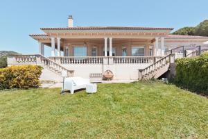 a large white house with a porch and a lawn at Luxury Seaview Villa by Olala Homes in Teià