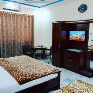 Hotel Sky Inn Clifton في كراتشي: غرفة فندقية بسريرين وطاولة