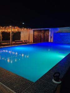 una piscina por la noche con iluminación azul en Disfruta de paz y armonía en huaral, en Huaral