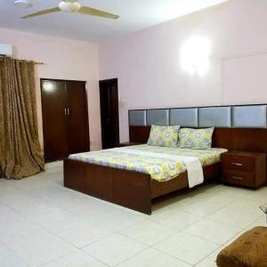 Hotel Sky Inn Clifton في كراتشي: غرفة نوم بسرير كبير في غرفة