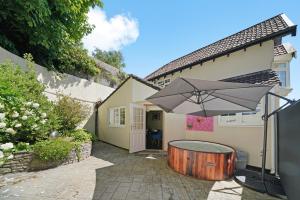 a house with a hot tub and an umbrella at Hot-Tub Heaven in Bristol - Games Room in Bristol