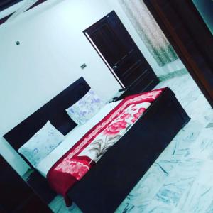 een bed met een rood kussen erop bij Hotel Sky Inn Clifton in Karachi