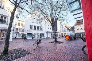 a bike parked on a brick street with buildings at nobilis Apartment - 8 Pers - Marktplatz - Netflix - PS4 in Lingen