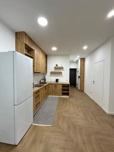 a kitchen with a white refrigerator and wooden cabinets at Modern apartament in Mukacheve