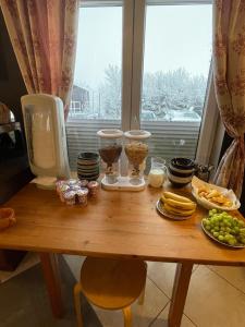 a wooden table with food on it with a window at Good Spot Zieleniec Twin Eco 01 in Duszniki Zdrój