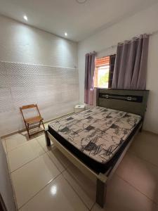 Ceará-MirimにあるCasa de Praia Muriu Beachのベッドルーム1室(ベッド1台、椅子付)