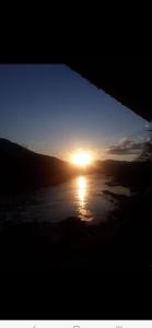 a sunset over a body of water with the sun setting at Janh Ya phone Guesthouse in Pakbeng