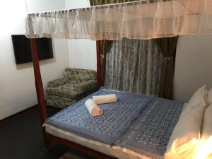a bedroom with a bed and a chair at Aloy's Residence in Digana