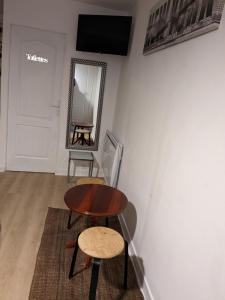 a table and stool in a room with a mirror at À 7 minutes de l'aéroport CDG 1 in Thieux