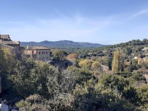 una ciudad en una colina con árboles y edificios en Maison restaurée à l'ancienne avec terrasse, en Jouques