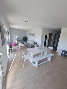 uma sala de estar com uma mesa branca e cadeiras em Bel appartement lumineux neuf em Clermont-Ferrand