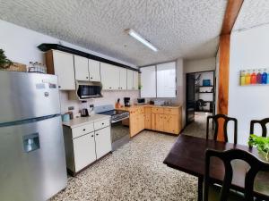 a kitchen with white cabinets and a stainless steel refrigerator at 714 Studios in San José