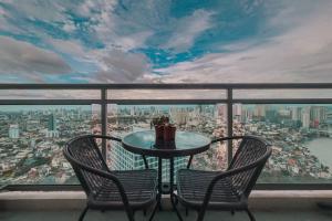 a table and chairs on a balcony with a view of a city at Serene Stays by Aki in Manila