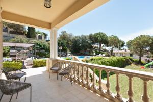 a balcony with chairs and a view of a pool at Luxury Seaview Villa by Olala Homes in Teià
