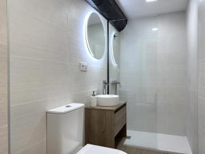 a bathroom with a toilet and a sink and a mirror at LA CAPRICHOSA DE ALCOR in Bozoo